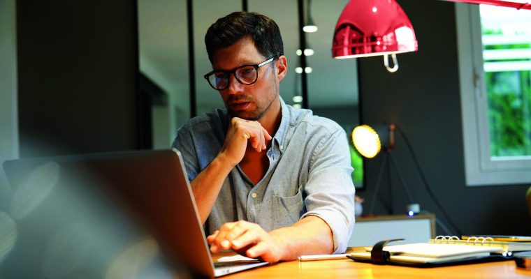 Middle-aged man working on laptop in office