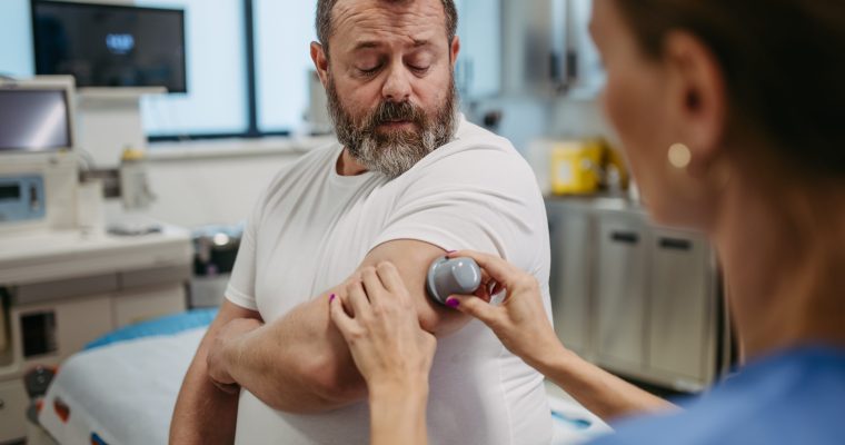 Doctor,Applying,A,Continuous,Glucose,Monitor,Sensor,On,Patient's,Arm.